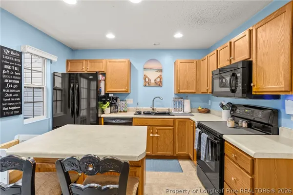 a kitchen with a stove a sink a dining table and chairs