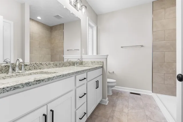 a bathroom with a granite countertop sink toilet and shower