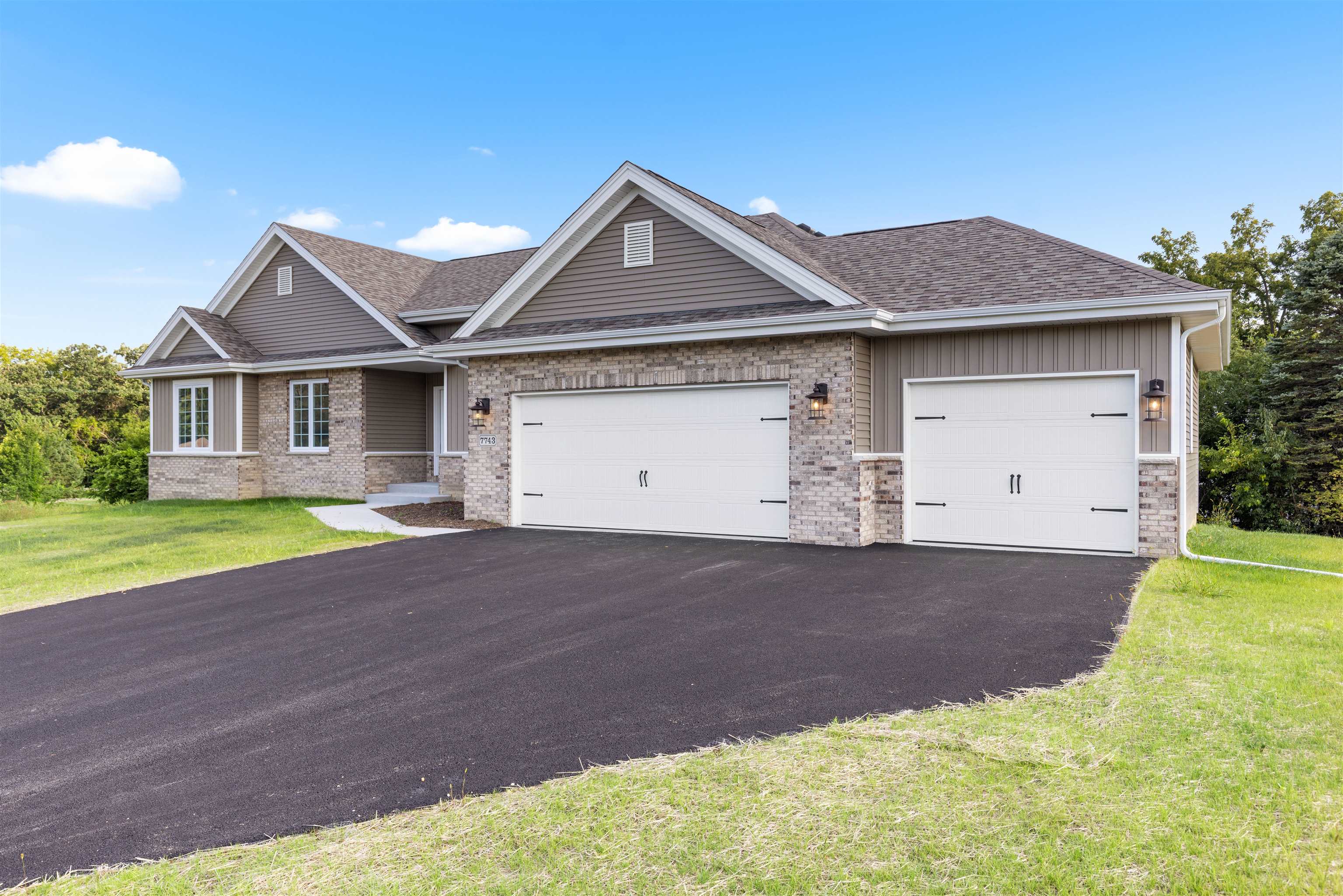 7743 Cherry Hill Road Cherry Valley, IL 61016 - Photo 2 of 18 a front view of a house with a yard and garage
