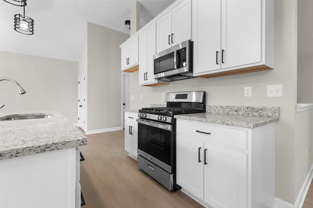 a kitchen with stainless steel appliances granite countertop a sink stove and microwave