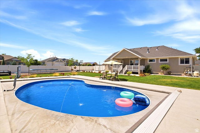 2973 West Red Sand Rd Haven Ogden, UT 84401 - Photo 4 of 30 Expansive backyard featuring a freeform swimming pool with a concrete surround