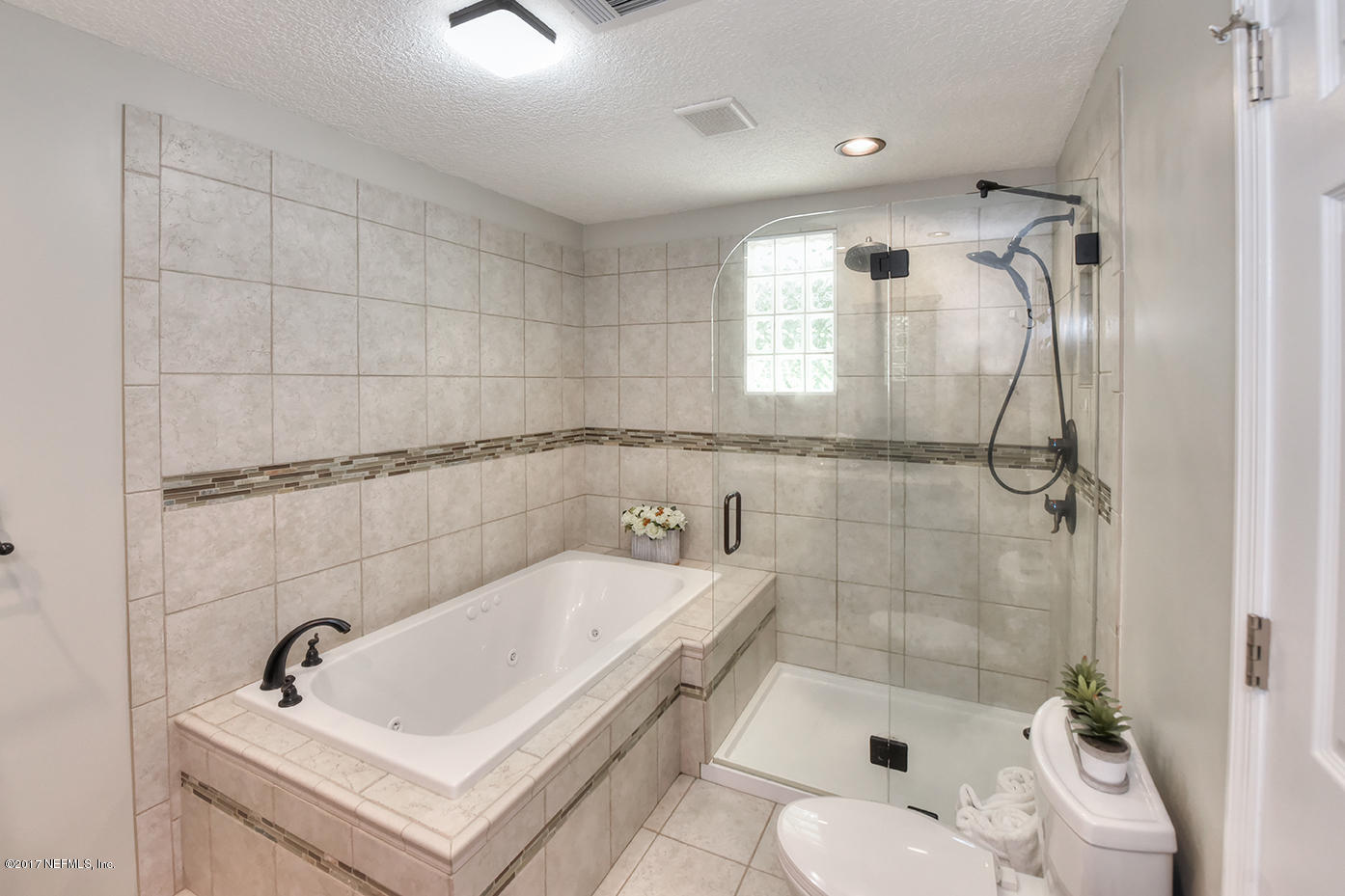 4640 Tanbark Road Jacksonville, FL 32210 - Photo 17 of 28 a bathroom with a sink a toilet and shower