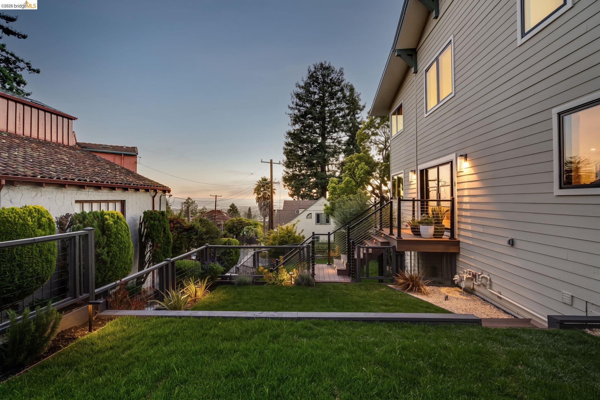 1409 Scenic Avenue Berkeley, CA 94708 - Photo 11 of 28 Expansive tiered backyard featuring a manicured lawn, a gravel pathway, and integrated landscape lighting