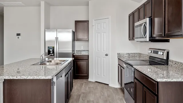 a kitchen with granite countertop a sink and steel appliances