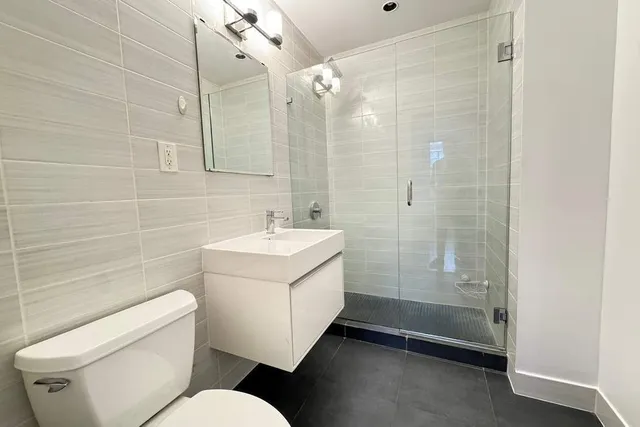 a bathroom with a sink mirror vanity and toilet