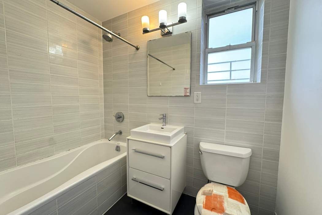 51 East 128th Street, Unit 6A Manhattan, NY 10035 - Photo 12 of 14 a bathroom with a sink a toilet and shower