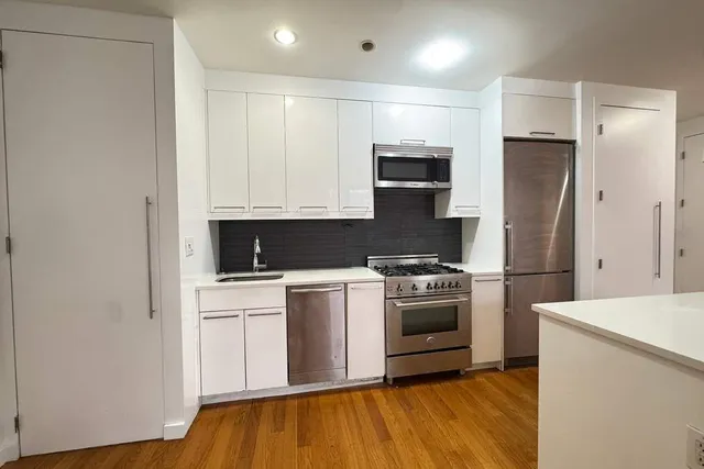 a kitchen with stainless steel appliances granite countertop a stove a sink and a refrigerator