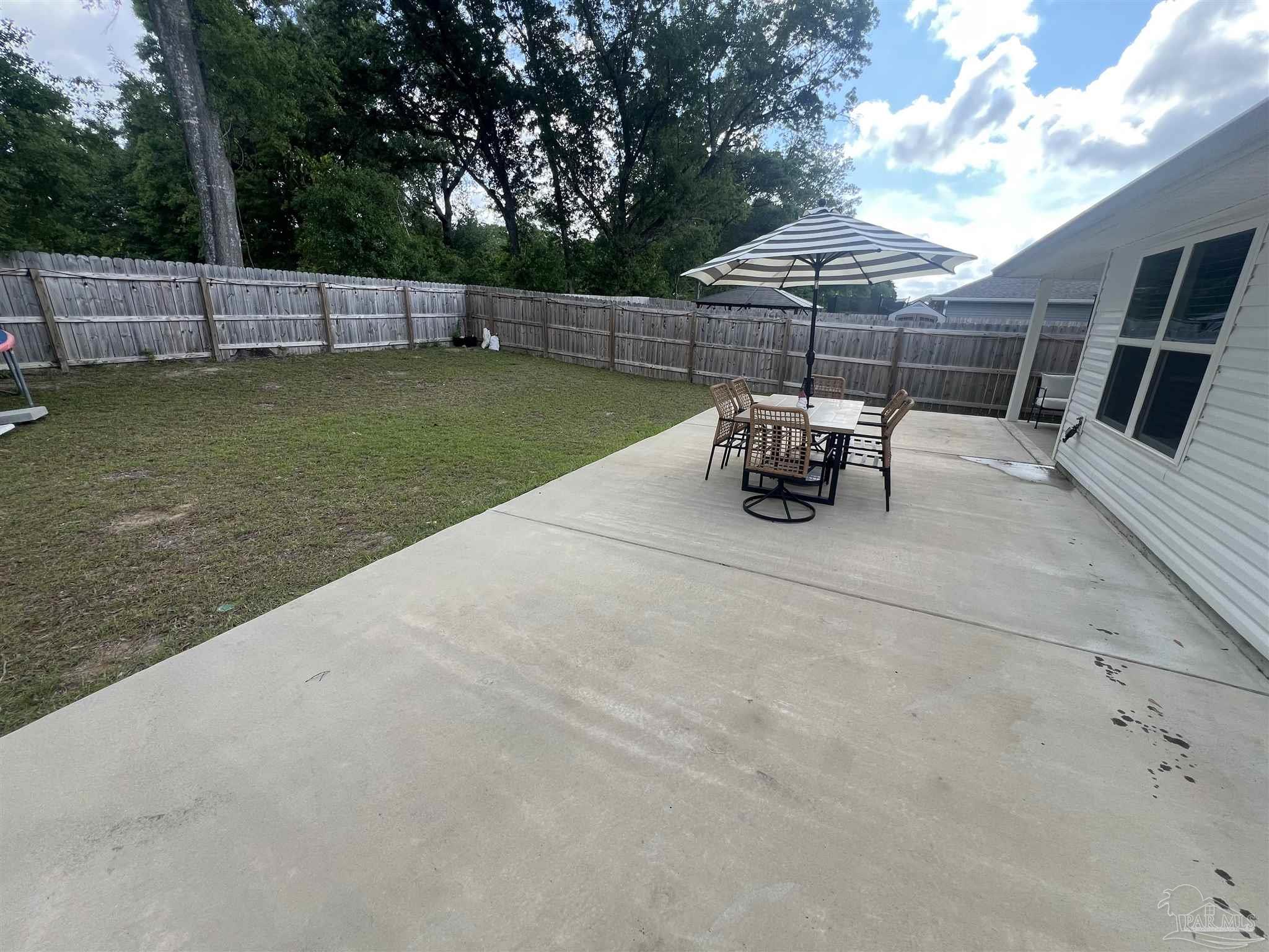 5253 Peach Drive Pace, FL 32571 - Photo 17 of 23 a view of a backyard with a sitting area and a garden
