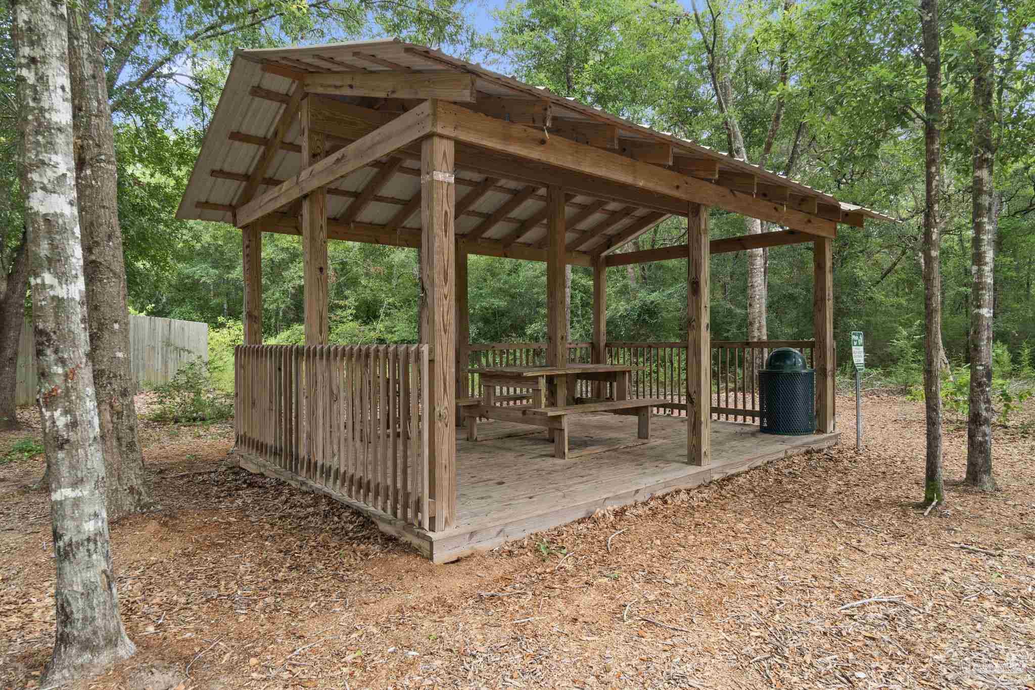 5253 Peach Drive Pace, FL 32571 - Photo 23 of 23 a backyard of a house with table and chairs under an umbrella