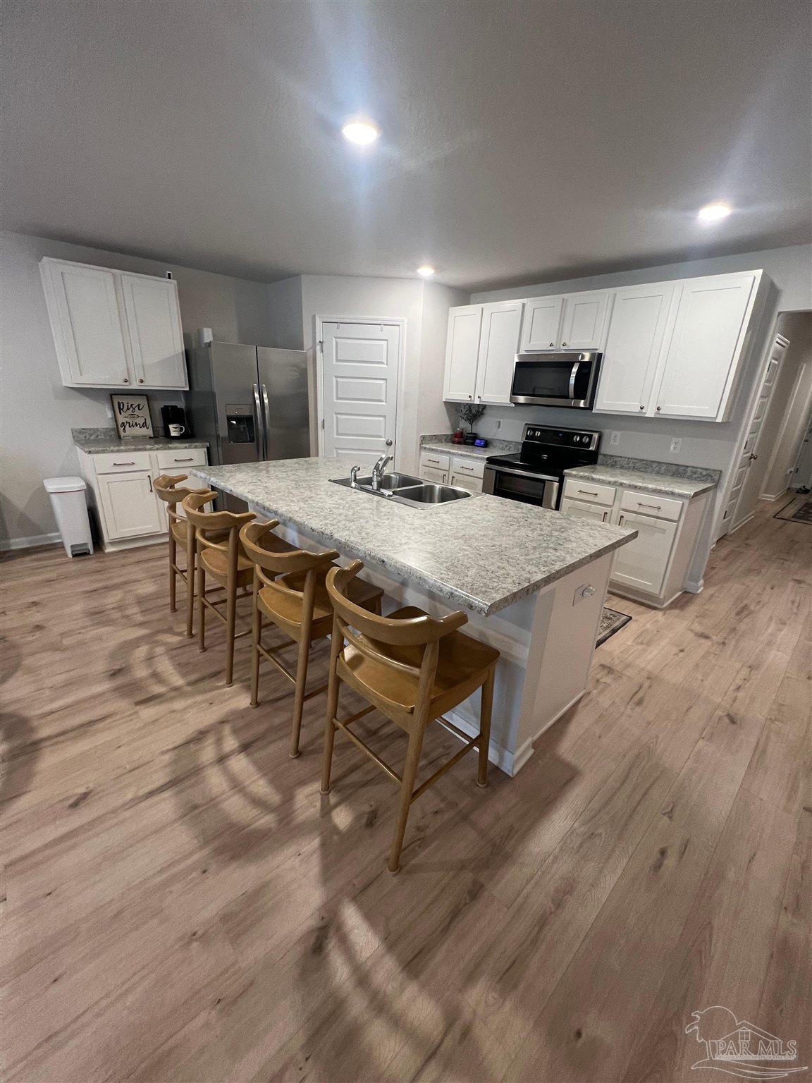 5253 Peach Drive Pace, FL 32571 - Photo 4 of 23 a room with stainless steel appliances kitchen island granite countertop a table chairs sink and cabinets