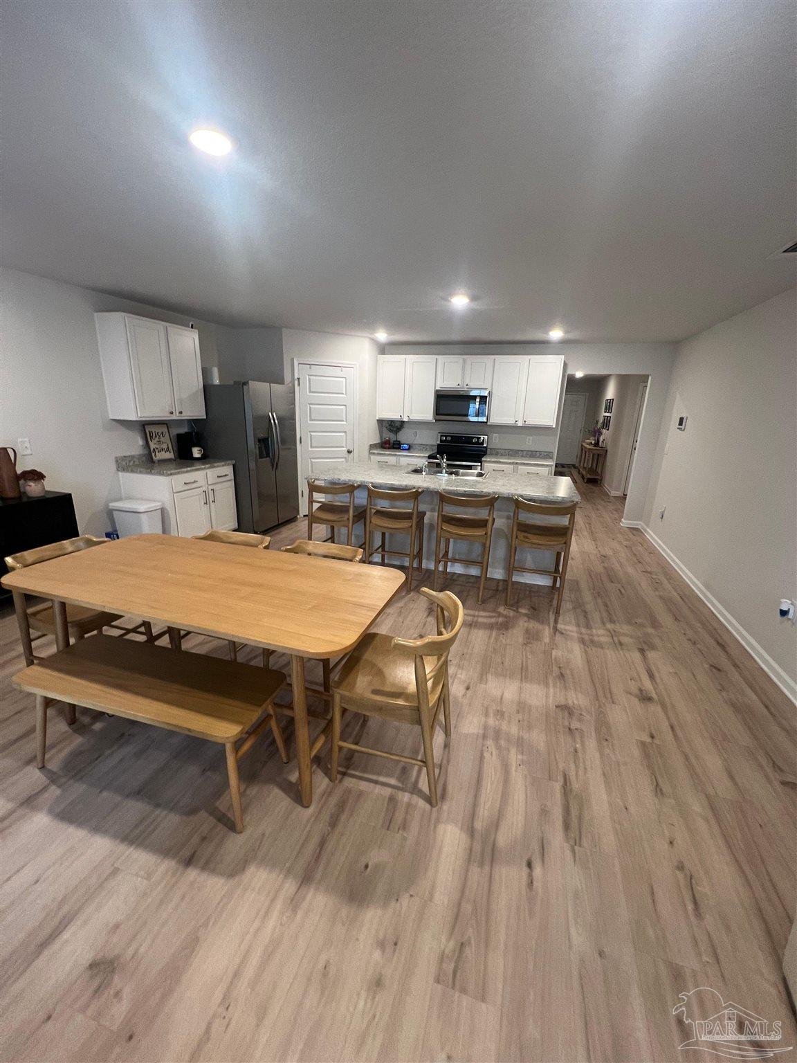 5253 Peach Drive Pace, FL 32571 - Photo 7 of 23 a living room with stainless steel appliances furniture a rug kitchen view and a table