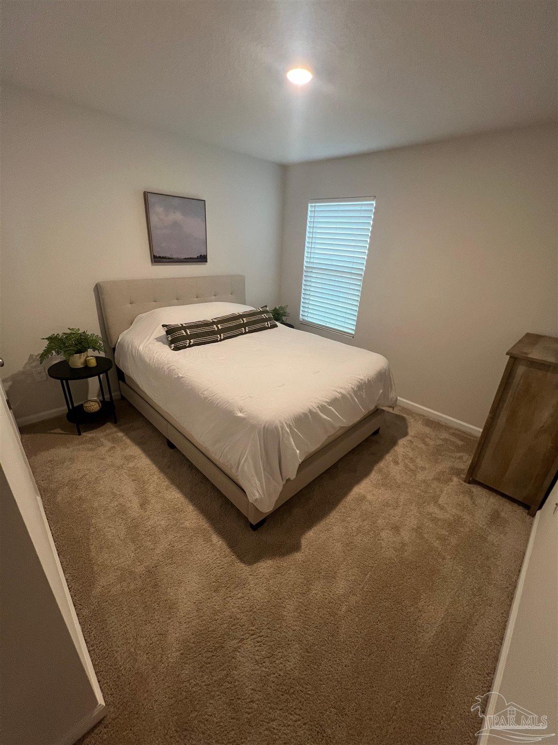 5253 Peach Drive Pace, FL 32571 - Photo 9 of 23 a bedroom with a bed and a lamp on table