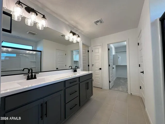 a spacious bathroom with a double vanity sink mirror and shower