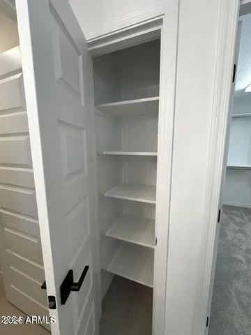 a view of walk in closet with empty racks
