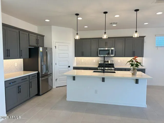 a kitchen with kitchen island a sink stainless steel appliances and cabinets