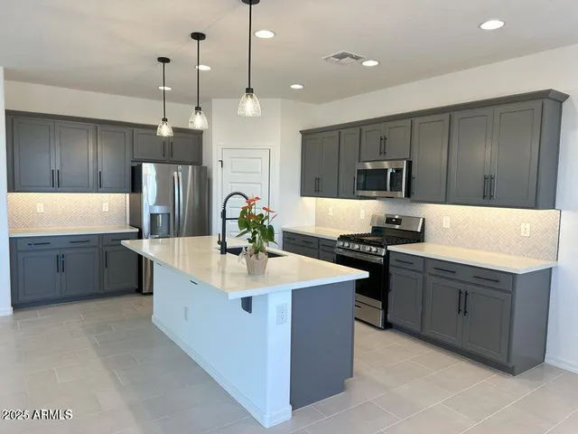 a large kitchen with kitchen island a sink stainless steel appliances and cabinets