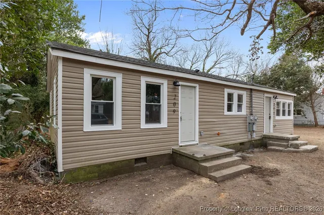 a view of a house with a yard and wooden fence