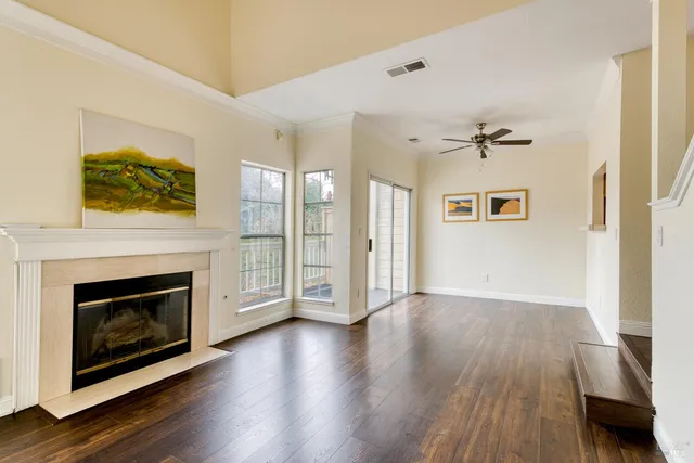 a view of a livingroom with wooden floor and a fireplace