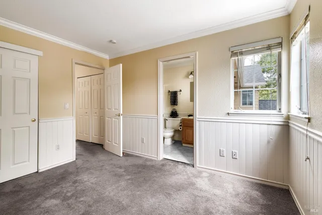an empty room with a window and a kitchen