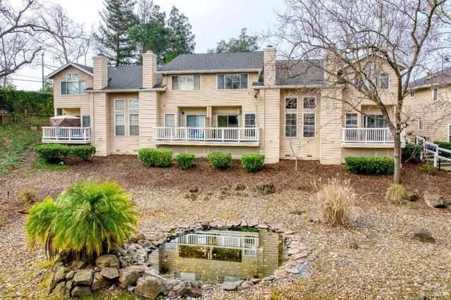 a front view of a house with a yard and potted plants