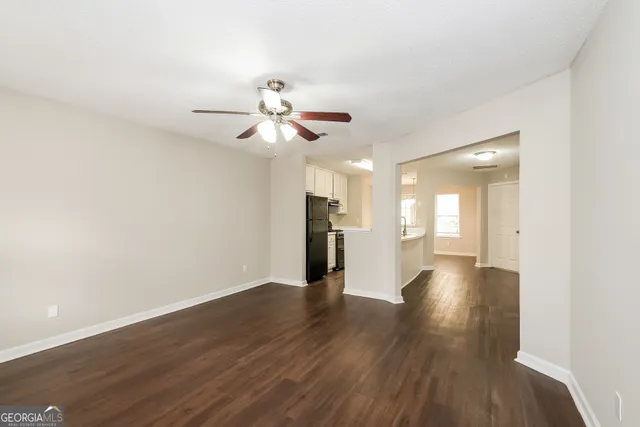 a view of a room with wooden floor and ceiling fan