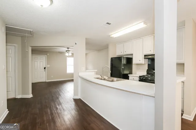 a view of a kitchen with a sink and wooden floor