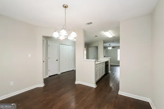 a kitchen that has a refrigerator a sink and wooden floor