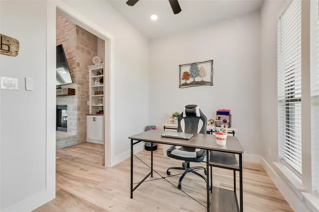 a view of a workspace with furniture and a window