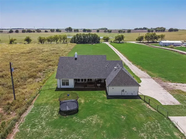 a aerial view of a house with big yard and large trees