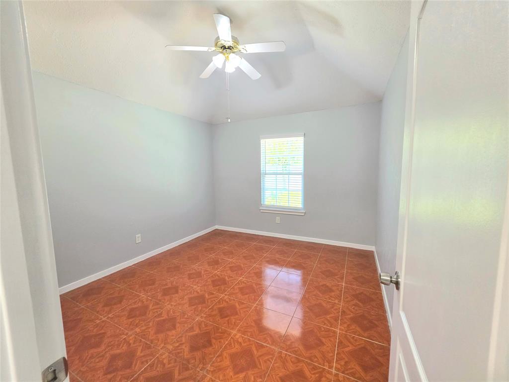 13618 Sablegrove Lane Houston, TX 77014 - Photo 21 of 30 an empty room with a chandelier fan and windows