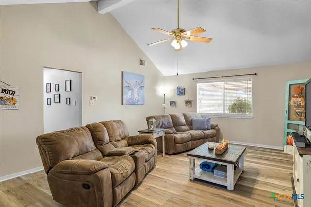 a living room with furniture a chandelier and a window