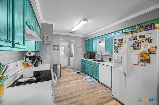 a kitchen with stainless steel appliances a stove a refrigerator a sink dishwasher and wooden cabinets with wooden floor