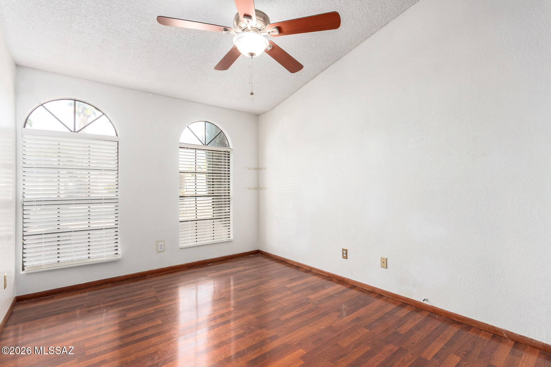 5331 West Eaglestone Loop Tucson, AZ 85742 - Photo 22 of 35 an empty room with wooden floor chandelier and windows