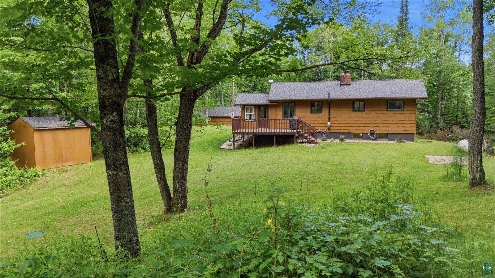 6377 Bergstrom Road Saginaw, MN 55779 - Photo 20 of 20 Expansive green lawn surrounds a wood-sided residence with a dark shingled roof
