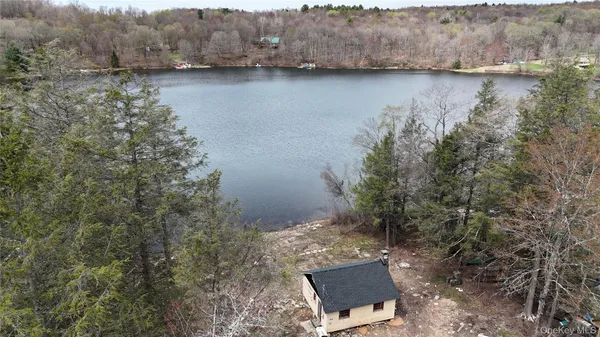 an aerial view of a house with a yard and lake view