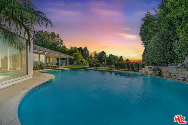 a view of a house with pool and a yard