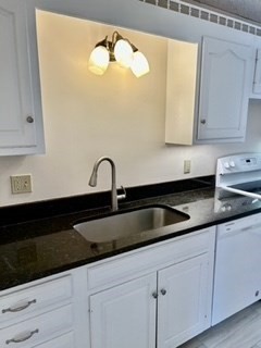 40 Village Road, Unit 610 Middleton, MA 01949 - Photo 14 of 36 a kitchen with granite countertop white cabinets and sink