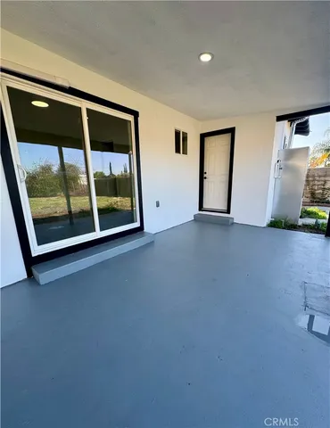 a view of an empty room with glass door and balcony