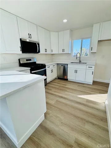 a kitchen with stainless steel appliances a stove a sink and a microwave