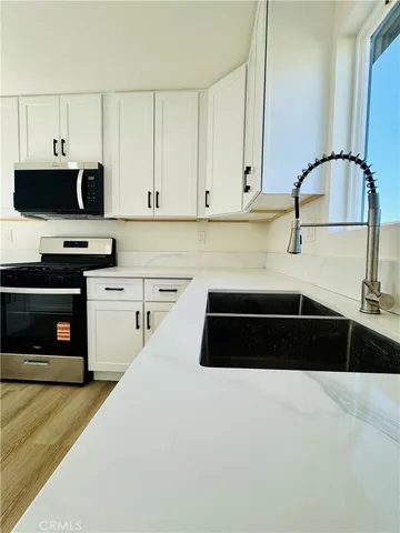 a kitchen with a sink and white cabinets