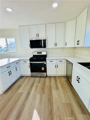 a large kitchen with cabinets stainless steel appliances and a counter space