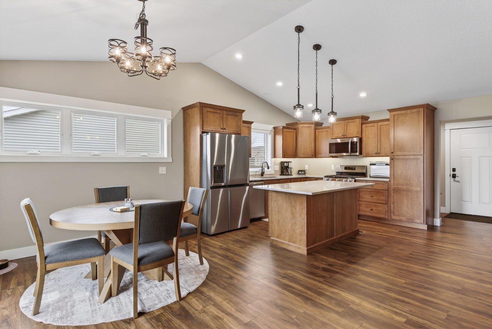 1439 Rhinelander Drive Davenport, IA 52804 - Photo 5 of 43 a kitchen with stainless steel appliances kitchen island granite countertop a table chairs and a refrigerator