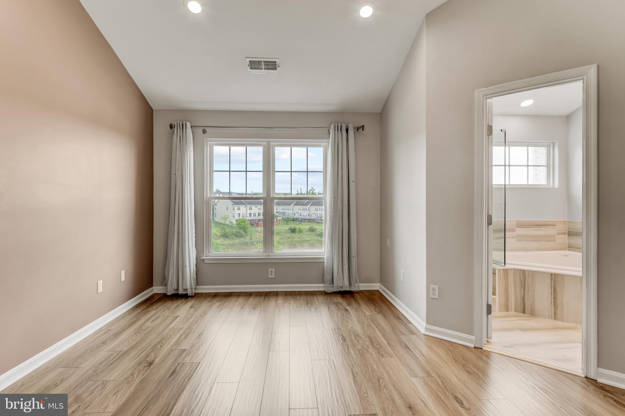 9183 Cascade Falls Drive Bristow, VA 20136 - Photo 30 of 45 an empty room with wooden floor and windows