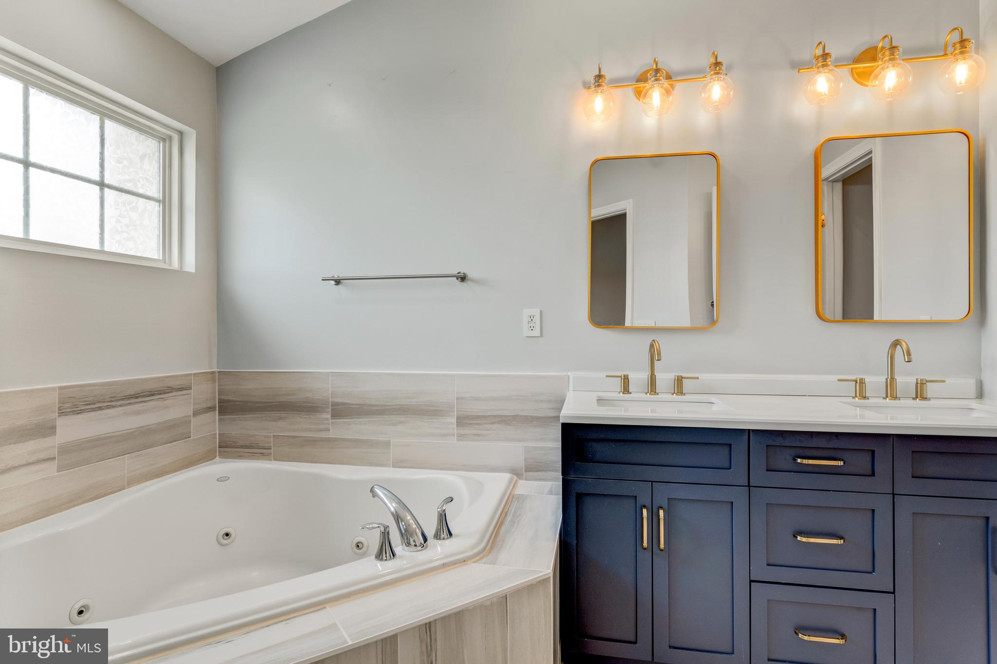 9183 Cascade Falls Drive Bristow, VA 20136 - Photo 34 of 45 a bathroom with a tub sink and mirror