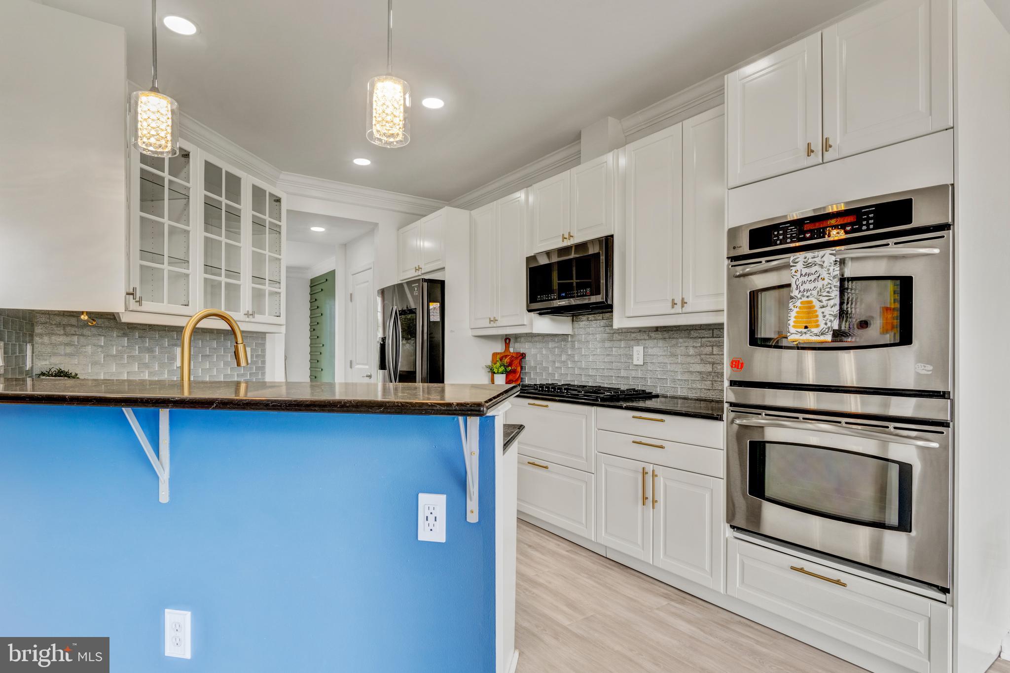 9183 Cascade Falls Drive Bristow, VA 20136 - Photo 5 of 45 a kitchen with stainless steel appliances granite countertop a stove a sink and a microwave