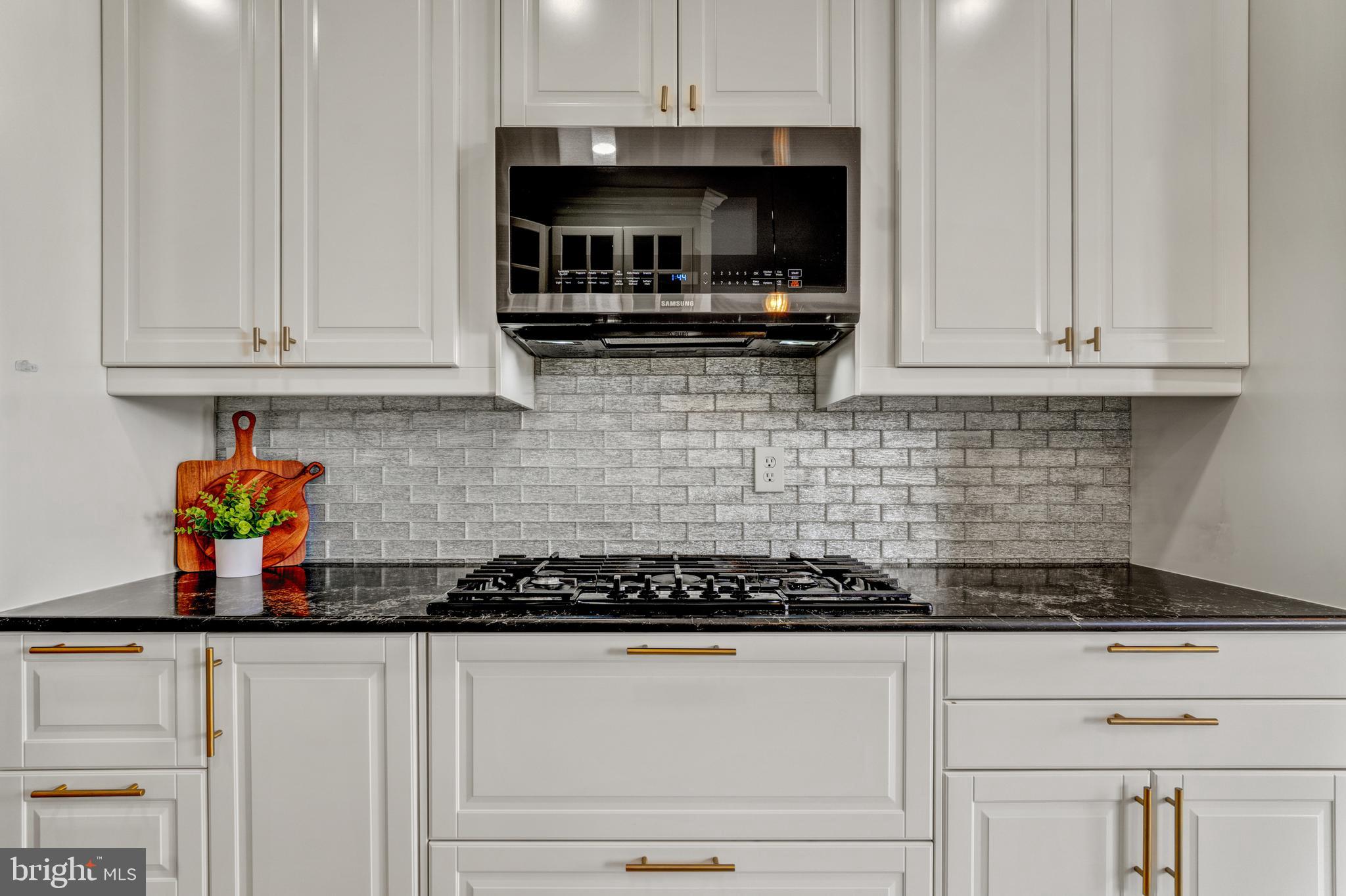 9183 Cascade Falls Drive Bristow, VA 20136 - Photo 6 of 45 a kitchen with granite countertop white cabinets and stainless steel appliances