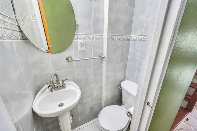 a bathroom with a sink toilet and a mirror