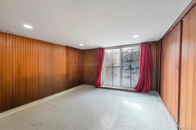 an empty room with floor to ceiling window and carpet