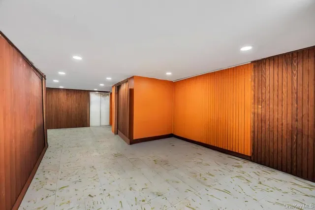an empty room with wooden floor and natural light
