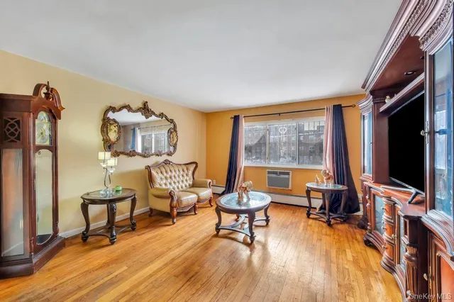 a living room with furniture a flat screen tv and a floor to ceiling window